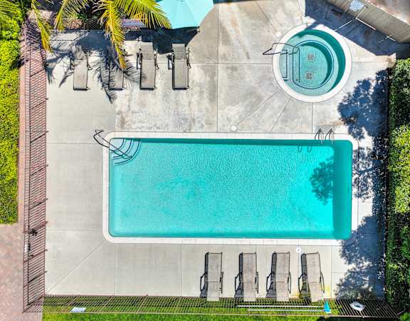 an aerial view of a swimming pool with a pool table and umbrellas