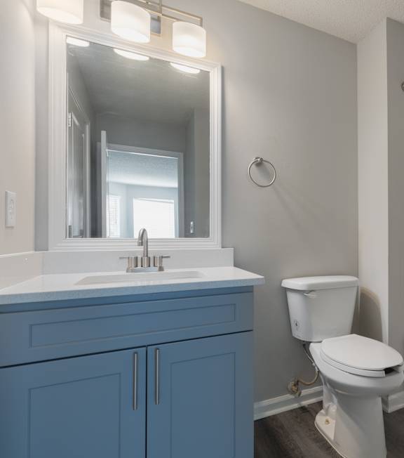 A white toilet sits next to a white sink in a bathroom.