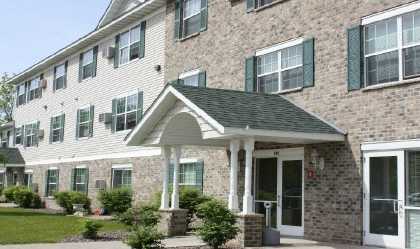 the front of a brick apartment building with a porch