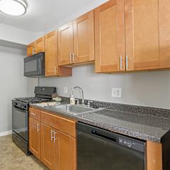 A kitchen with wooden cabinets and black appliances.