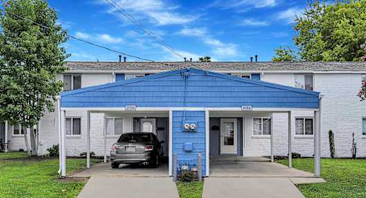 A blue house with a car parked in front.