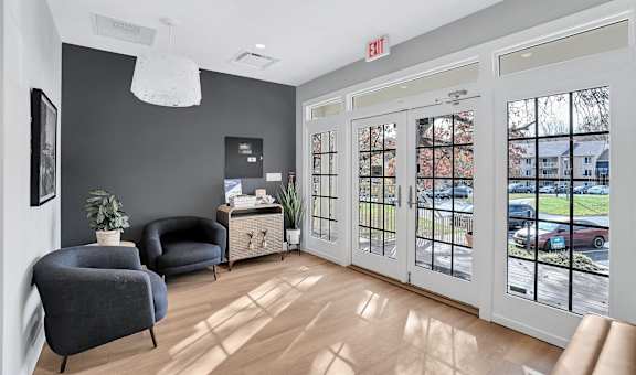 a living room with two chairs and a door to the street