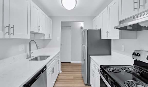 a white kitchen with white cabinets and stainless steel appliances