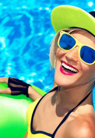 a woman in a yellow bikini and blue sunglasses in a pool