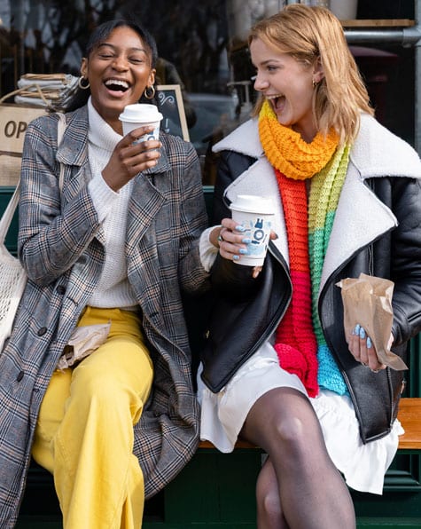 two women walking down the street with shopping bags