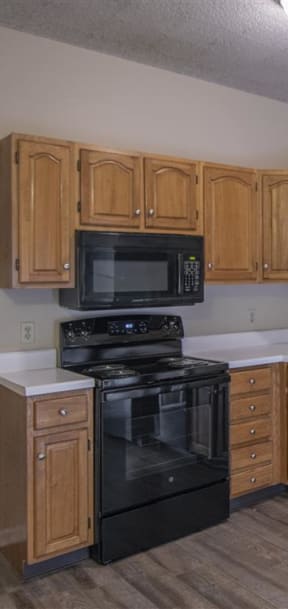 a kitchen with white cabinets and a black stove and refrigerator