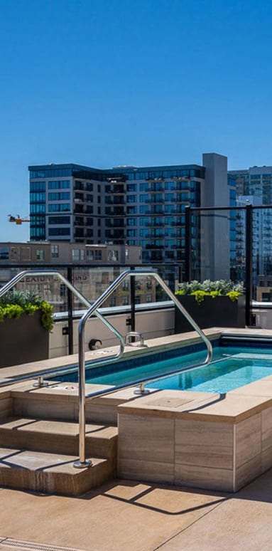 a swimming pool on a rooftop with a city in the background