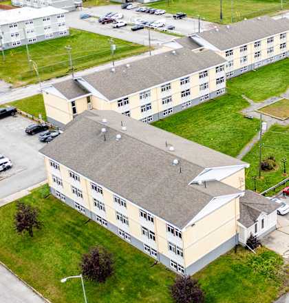 A large building with the word "SAN" on it is surrounded by a parking lot.
