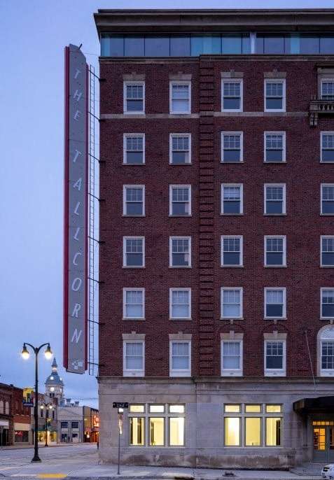 A tall red brick building with a sign that says "Theatricorn" on it.