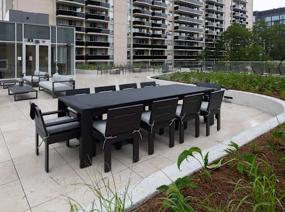 A black table and chairs set is placed on a patio.