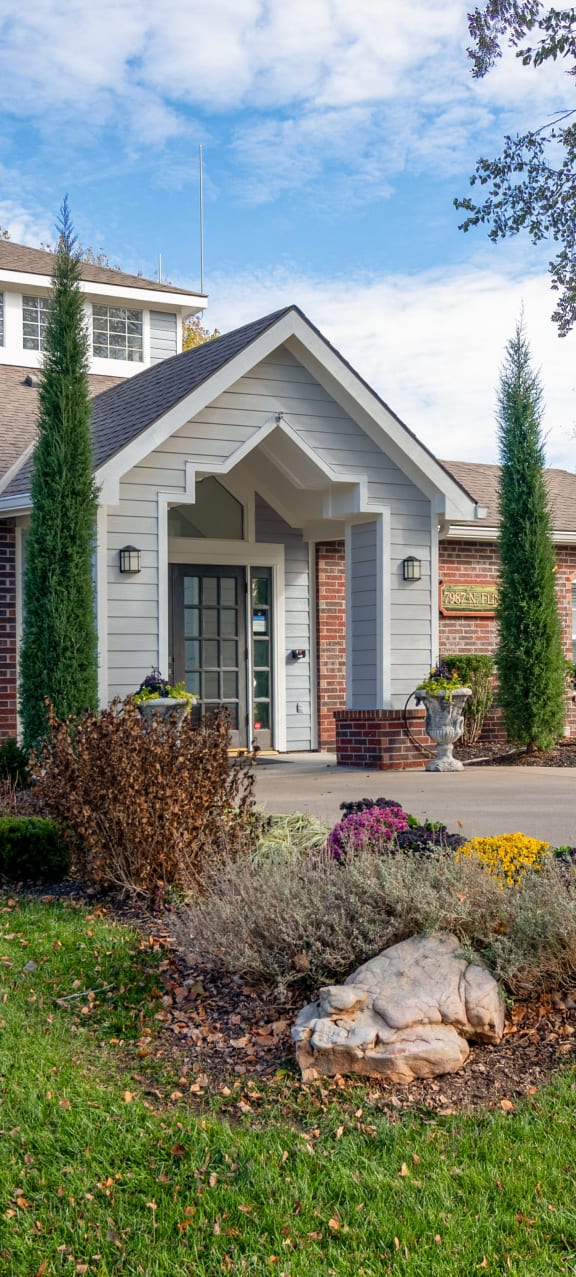 the front of a brick house with a walkway leading to the front door