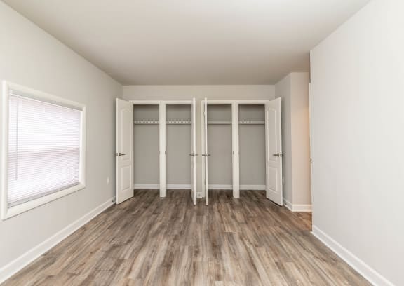 an empty room with hardwood floors and white walls