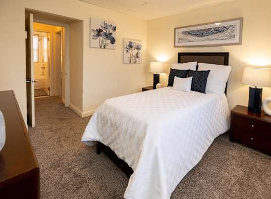 a bedroom with a large white bed and a closet