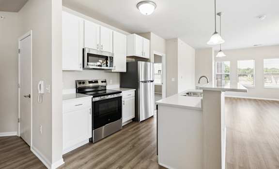 A modern kitchen with white cabinets and stainless steel appliances.