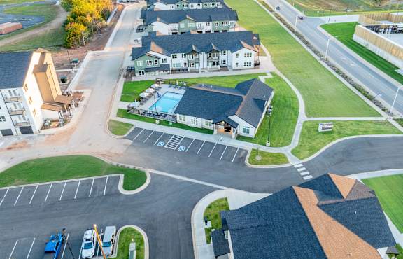 A bird's eye view of a residential area with houses, roads, and a swimming pool.