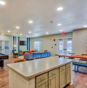 A white bathroom with wooden floors and a white toilet.at Hawthorne Pointe, Bondurant, 50035