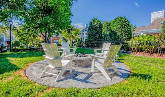Two chairs and a table are set up in a circle on a lawn.