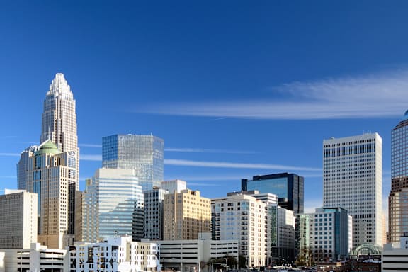 A city skyline with tall buildings and a clear blue sky.