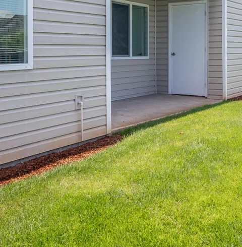 A balcony with a white railing is attached to a house with a brown siding.at Vancouver Mall Apartments, Vancouver, 98662