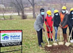 a group of people wearing masks are shoveling dirt into a hole