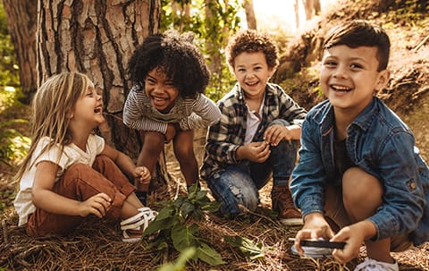 a group of children sitting under a tree