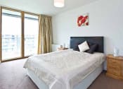 Thumbnail 2 of 5 - a bedroom with a bed and a large window