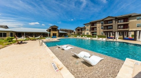 a large pool with a blue sky in the background at Legacy Creekside Apartments, San Antonio