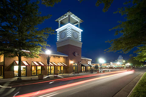 a clock tower on a city street at night
