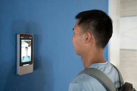 A man is looking at a digital display on a wall.