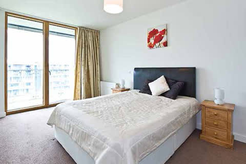 a bedroom with a bed and a large window