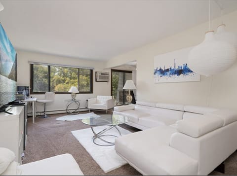 a living room with white furniture and a glass table