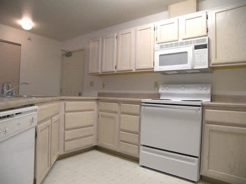 A kitchen with white appliances and white cabinets at Brighton Park 