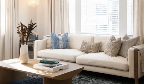 A living room with a white couch and a coffee table.