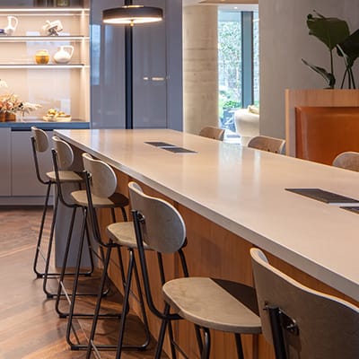 a kitchen with a long counter with chairs and a bar stool