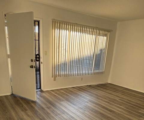 A room with a white door and a window with blinds.