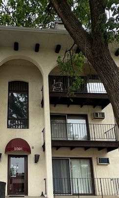 A white building with a balcony and a red awning.