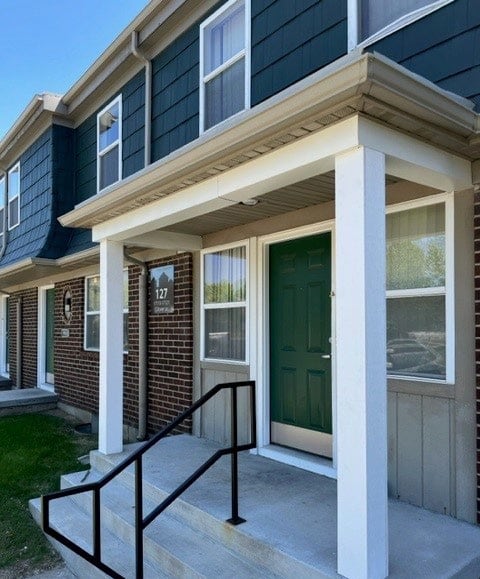 a house with a green door and black railing