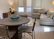 Thumbnail 19 of 41 - Modern living room and dining area with a table, chairs and sofa at unit 203, 739 South Ogden Drive.