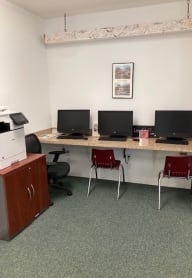 a computer room with three computers and a printer
