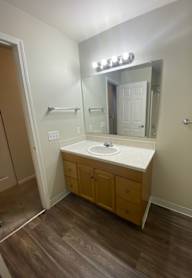 A small kitchen with a refrigerator, sink, and cabinets.