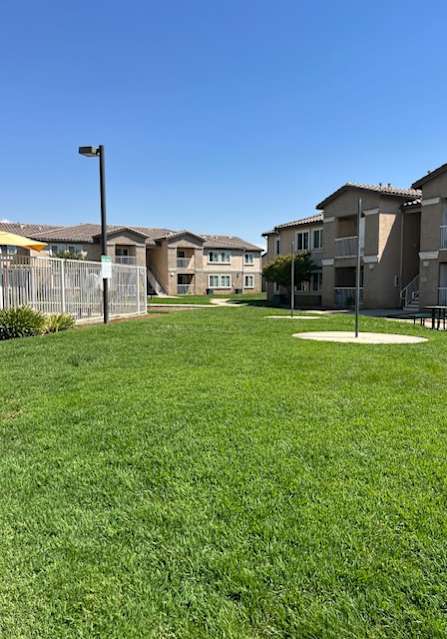 A grassy area in front of apartment buildings.
