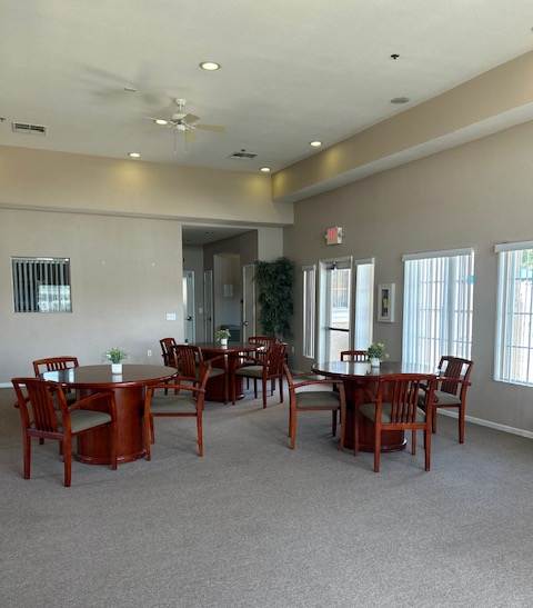 A room with a dining table and chairs.