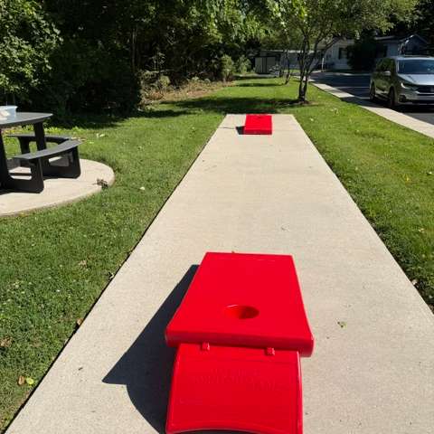A picnic area with a cornhole game set up.