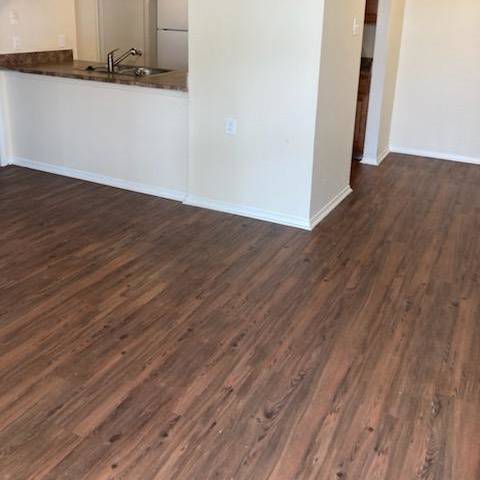 A room with wooden flooring and white walls.