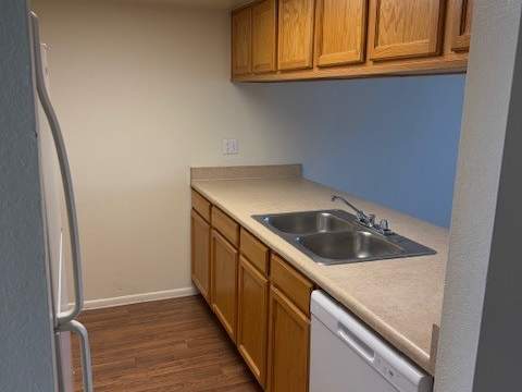 A kitchen with wooden cabinets and a white dishwasher at Ascent on Spence, Tempe, AZ 85281