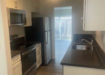 A kitchen with black countertops and white cabinets.