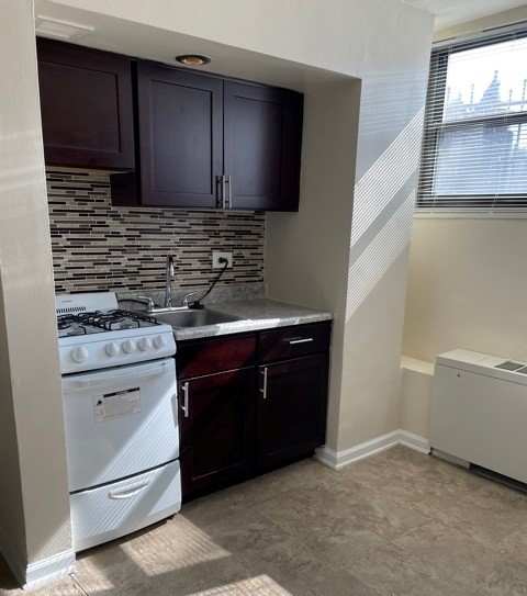 a kitchen with a stove a sink and a window