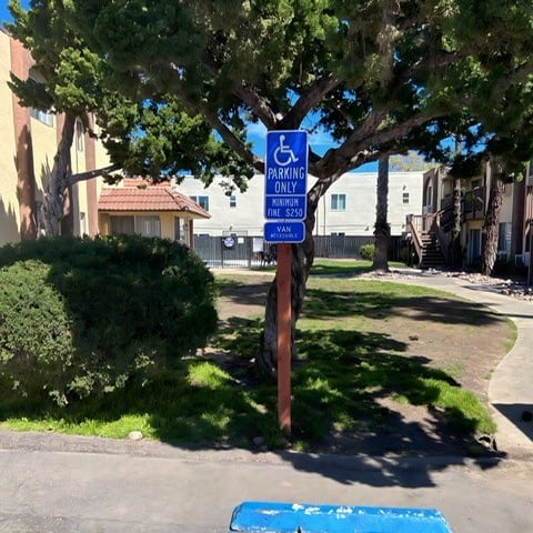 a blue handicapped parking sign in a parking lot