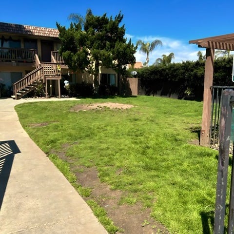 a yard with green grass and a house in the background
