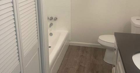 A white bathroom with a toilet, sink, and bathtub.